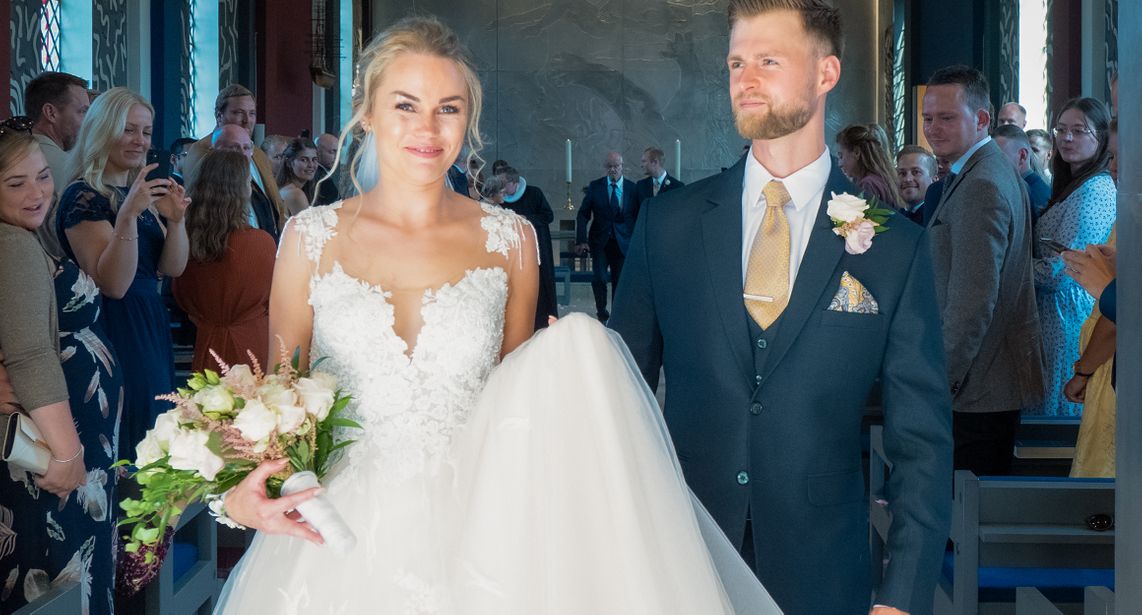 Bryllupsfotografen fanger brudepar på vej ud efter vielse i kirken